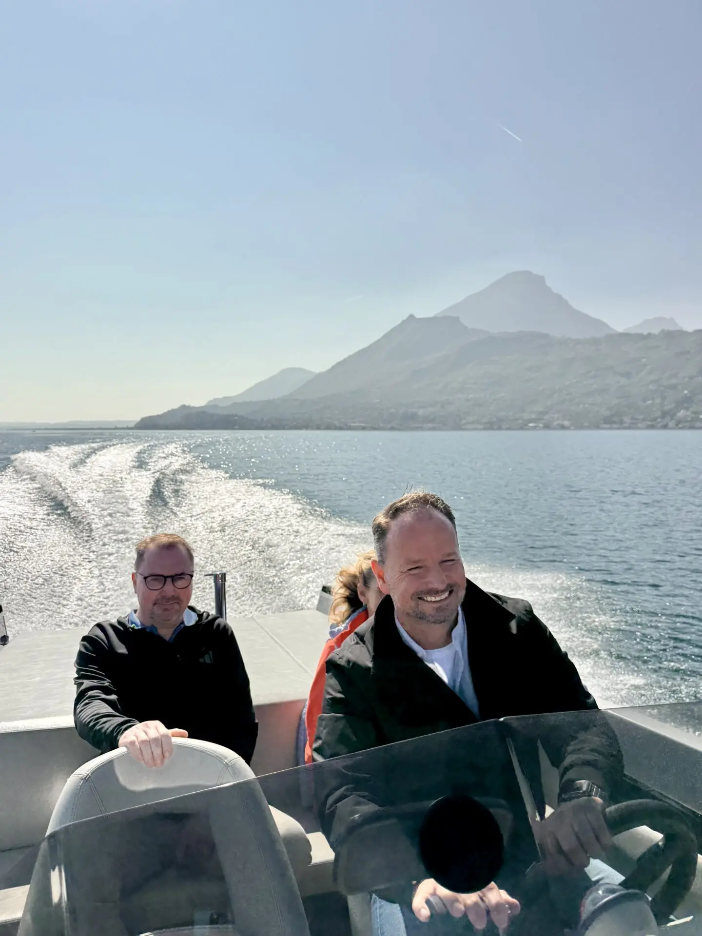 Bootsfahrt am Gardasee bei sonnigem Tageslicht: auf einer Frauscher 686 Lido mit Blick auf Gargnano und die Berge, klares blaues Wasser